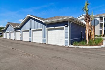 Private garages with white doors and blue siding